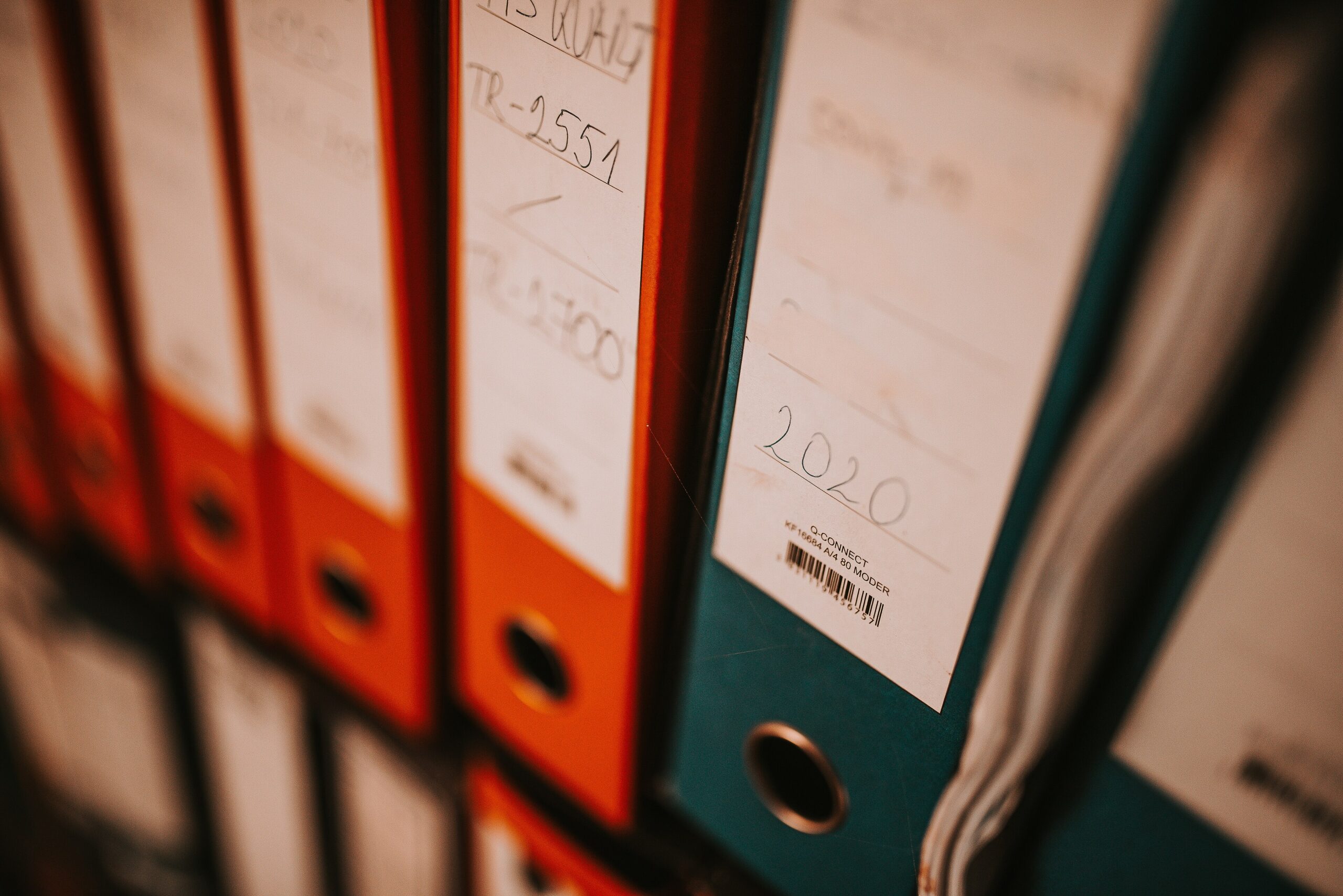 Collection-of-colorful-binders-on-a-shelf-for-storing-documents-in-an-office-setting.jpg Aktenordner in einem Büroregal