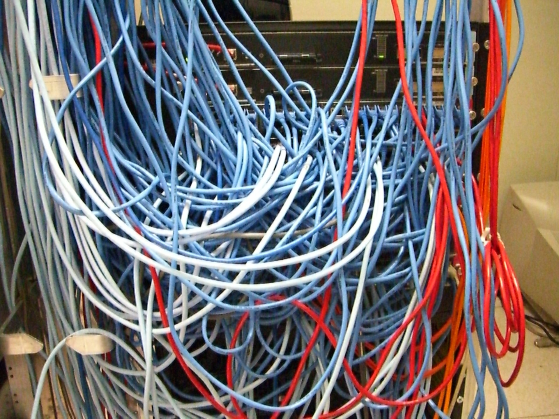 Server-Rack mit einem Gewirr aus Netzwerkkabeln Server-Rack mit einem Gewirr aus Netzwerkkabeln