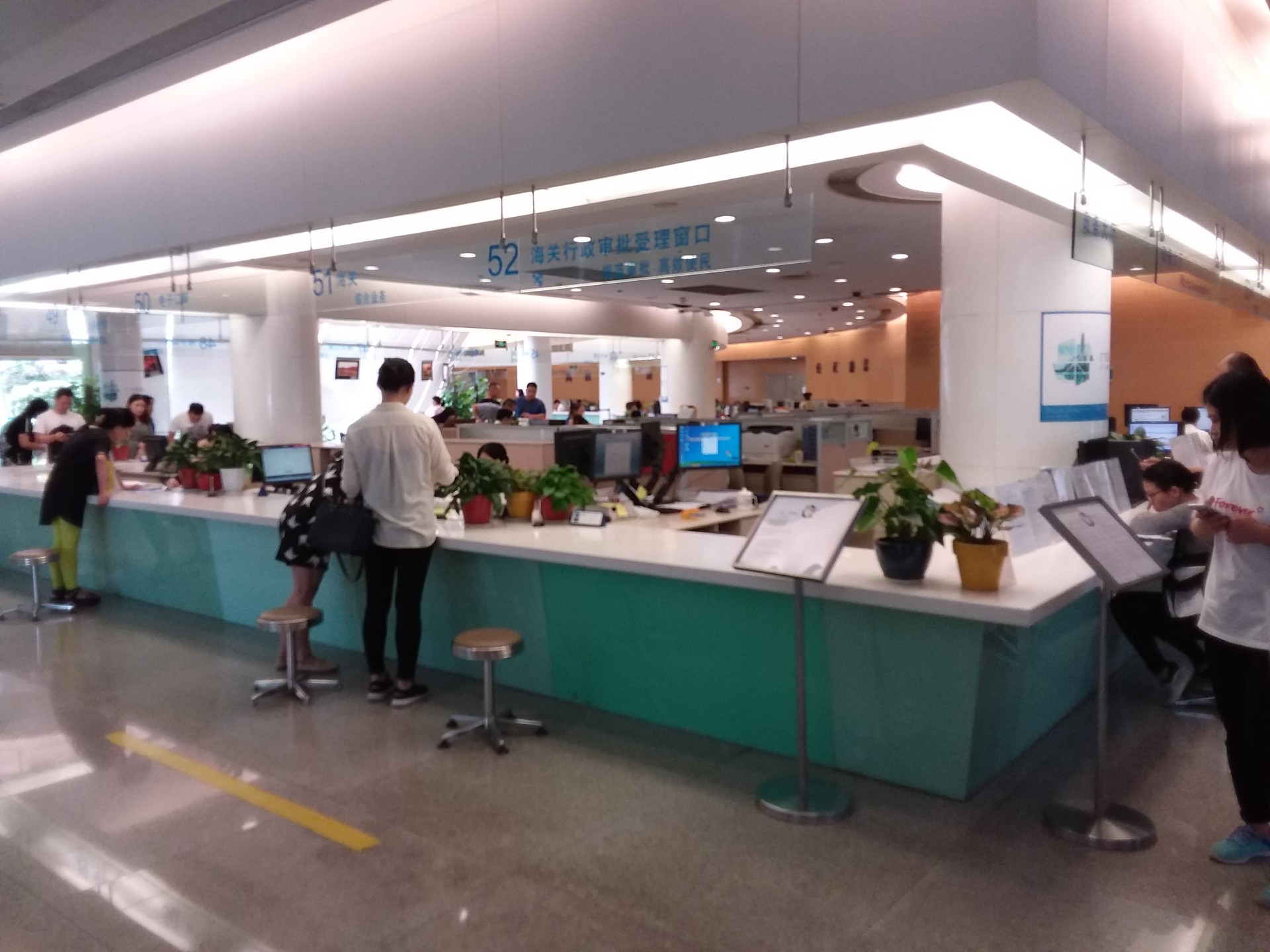 Nummerierte Schalter und Besucher im Verwaltungszentrum des Stadtbezirks Futian in Shenzhen
